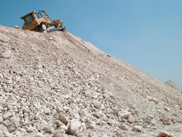 Mining machine travels along the embankment of gravel