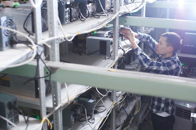 Mining. A man working on a farm for the extraction of crypto currencies. Bitcoin business