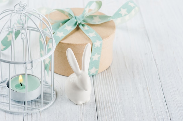 Mint green lit candle in white lantern with gift 