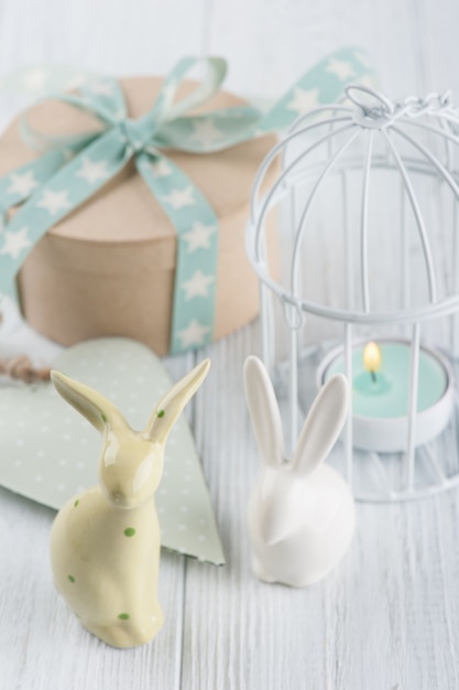 Mint green lit candle in white lantern with gift 