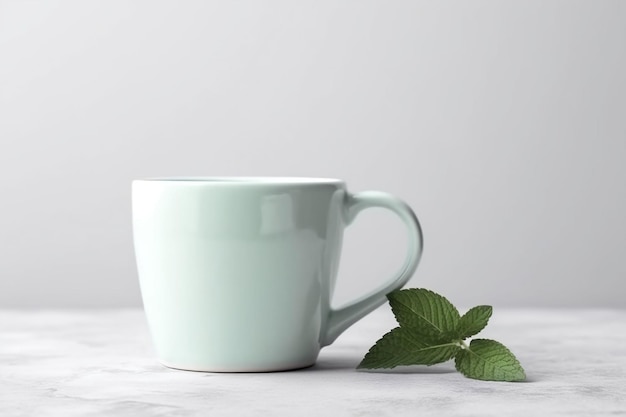 A mint green mug with a leaf next to it