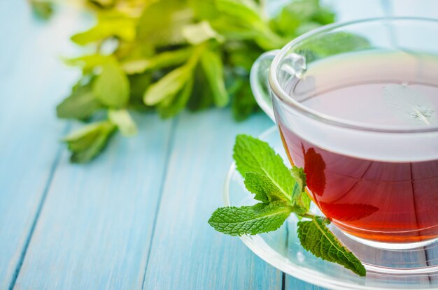 Photo mint tea in a glass cup on a wooden background