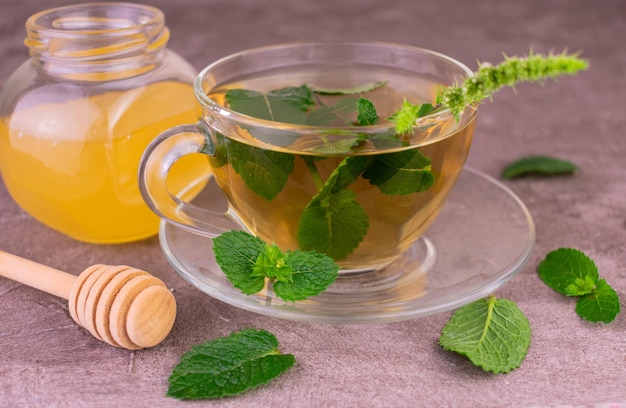 Mint tea with honey in a transparent cup. Close-up.