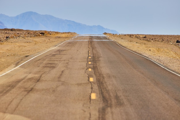 Mirage captured on road in desert landscape with mountains