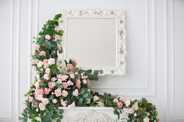 Mirror on a white wall decorated with flower garlands