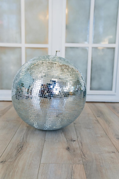 Mirrored disco ball on the floor in the room elements of decor in retro style accessories for parties and holidays