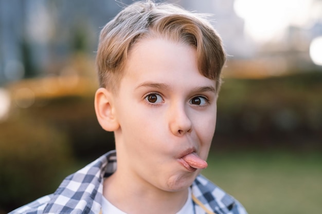 A mischievous teenager makes faces at the camera sticks out his tongue and indulges