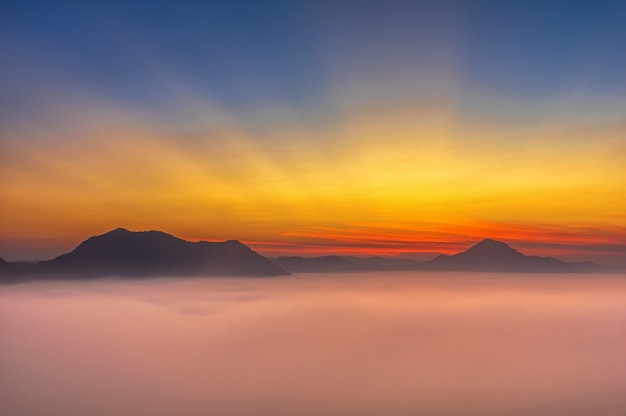 Misty Mountain with sun rays over Phu Thok mountain hills, Loei province, Thailand