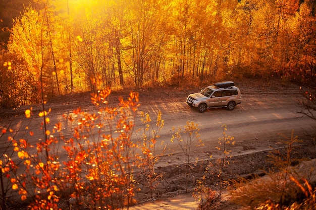 Mitsubishi Pajero on scenic autumn road in mountains