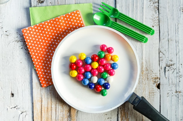 mix colorful chocolate sweets in heart form on a white pan