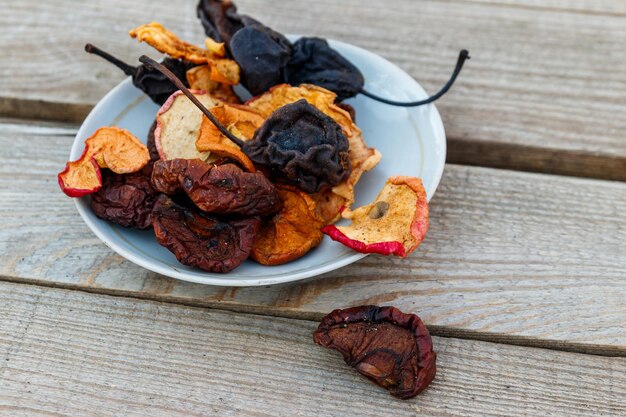 Photo mix of dried fruits in a plate on wooden table