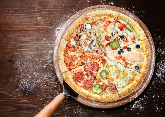 Mix of eight different pizzas on a wooden surface. menu concept of choice and diversity