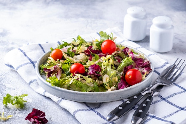 Mix of fresh green leaves and tomatoes on a plate Healthy food eating and diet concept