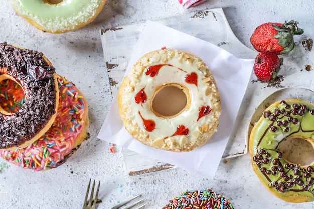 Mix of multicolored sweet donuts with colored sprinkles