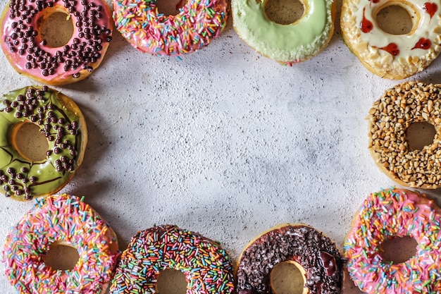 Mix of multicolored sweet donuts with colored sprinkles