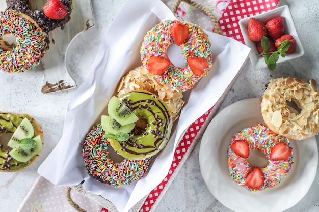 Mix of multicolored sweet donuts with colored sprinkles