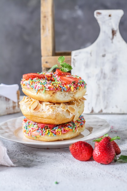 Mix of multicolored sweet donuts with colored sprinkles