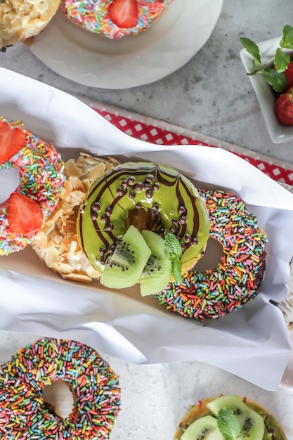 Mix of multicolored sweet donuts with colored sprinkles