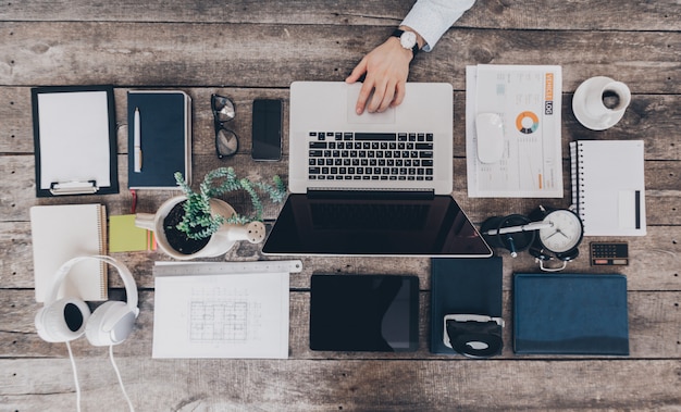 Mix of office supplies and gadgets on a wooden desk