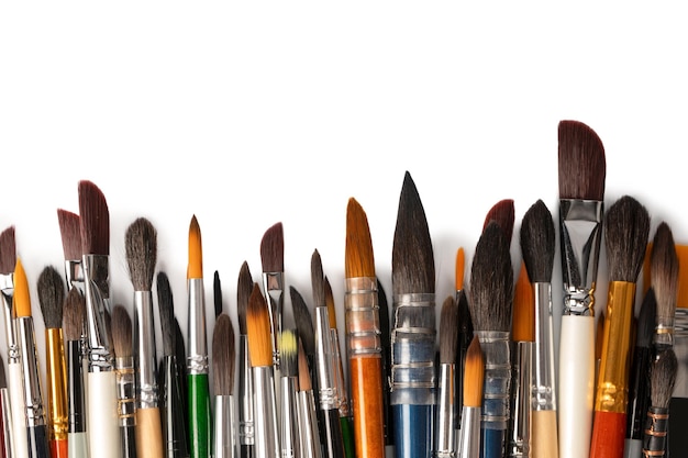 Mix of paint brushes in a row isolated on a white background Top view