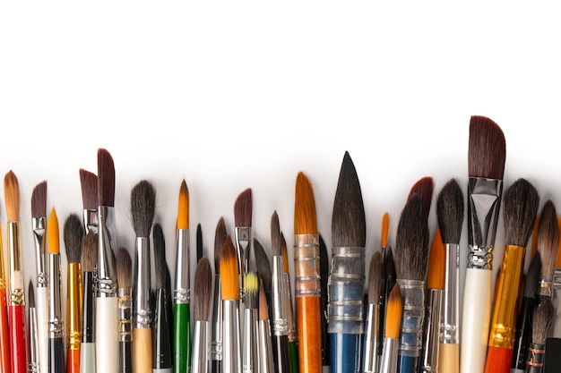 Photo mix of paint brushes in a row isolated on a white background top view