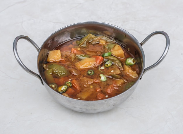 MIx sabzi or mixed vegetables aloo and shimla mirch potato and bell peppers served in karahi isolated on grey background side view of pakistani and indian spices food