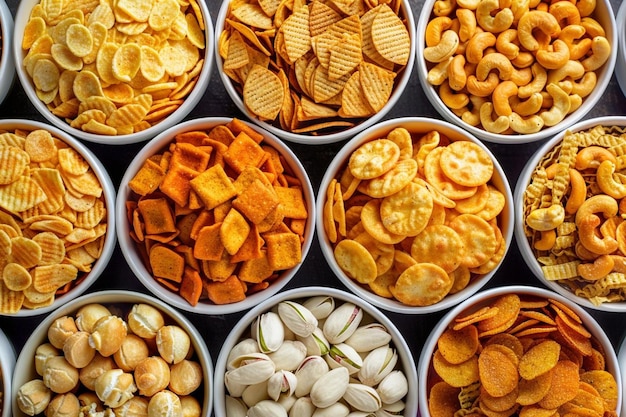 Photo mix of snacks variety of snacks such as nuts chips and popcorn