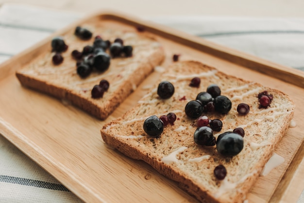 Mixed berries toast breads served on wooden plate