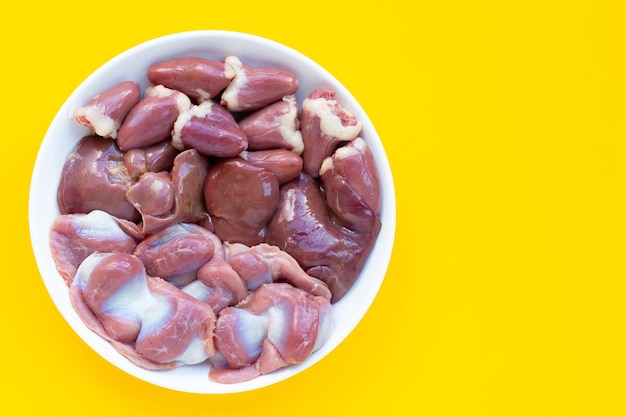 Mixed chicken entrails in white plate on yellow background