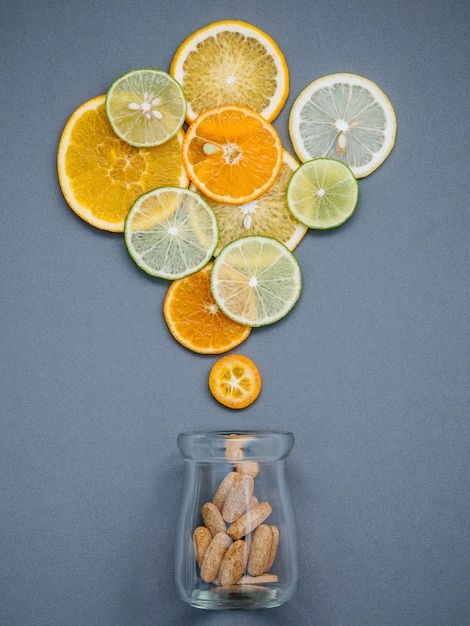   Mixed citrus fruits sliced on gray background flat lay.