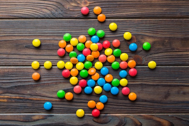 Mixed collection of colorful candy on colored background Flat lay top view frame of colorful chocolate coated candy