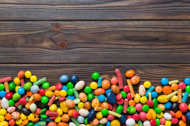 Mixed collection of colorful candy on colored background Flat lay top view frame of colorful chocolate coated candy