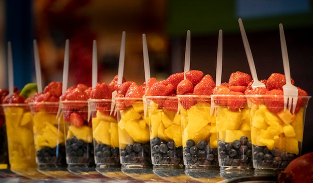 Mixed Fruit Salad arranged in plastic cups on a market stall.