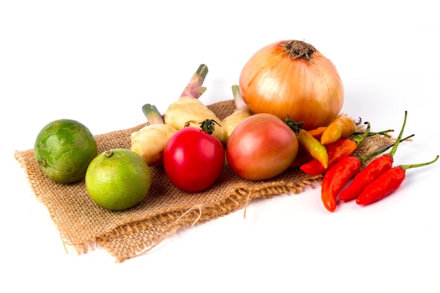 Mixed fruits and vegetables are placed on the sack on white background