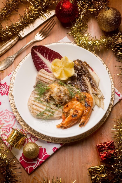 Mixed grilled fish with red chicory over christmas table