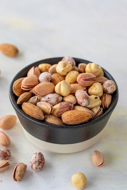 Mixed nuts in bowl on white background