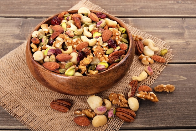 Mixed nuts in wooden bowl with linen mat