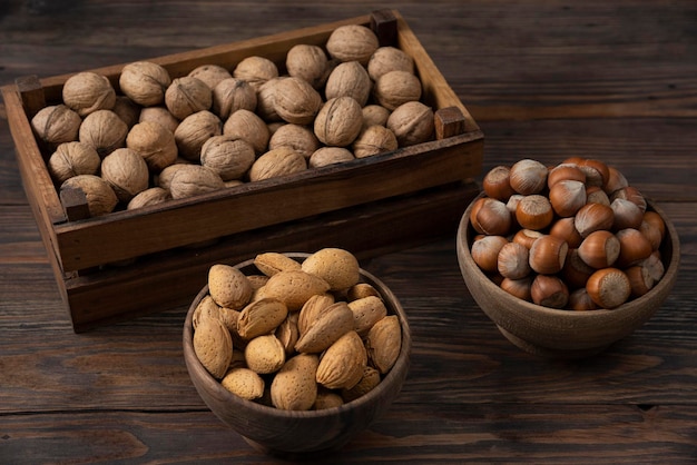 Mixed nuts in wooden bowl on wooden backround