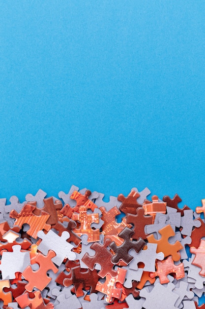 Mixed peaces of a colorful jigsaw puzzle lie on the blue background with copy space  strategy and so...