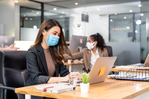 Mixed race of African and Asian business people wearing face masks in the office