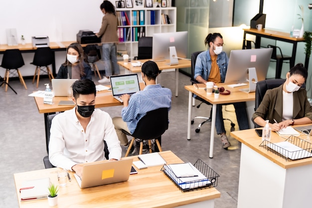 Mixed race of African and Asian business people wearing face masks in the office