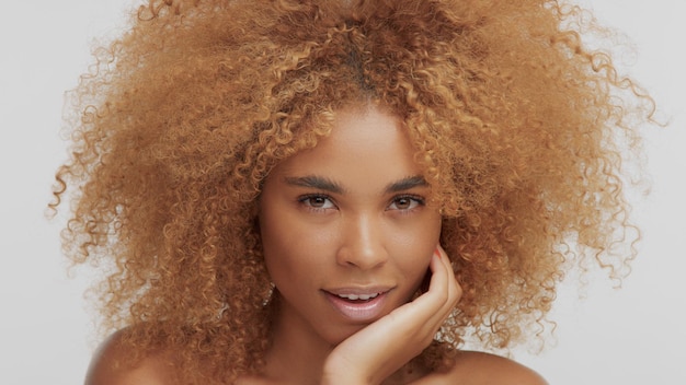 Mixed race black blonde model with curly hair chin down watching to the camera