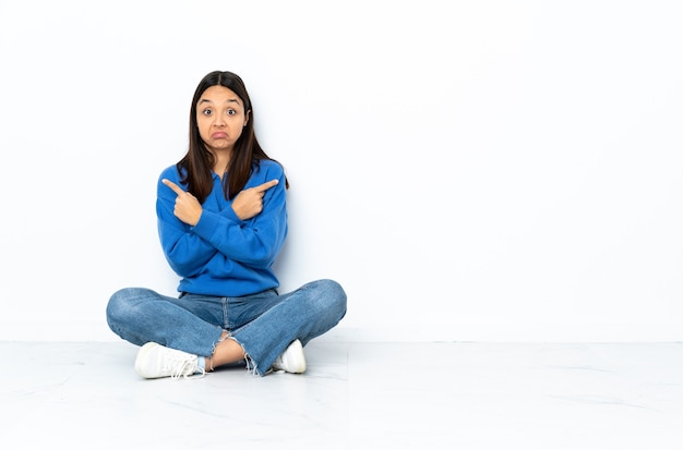 mixed race woman pointing to the laterals having doubts