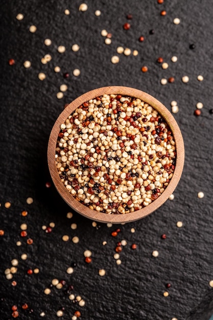 Mixed raw quinoa in bowls on wooden background Healthy and gluten free food Origin Peru vertical image top view place for text