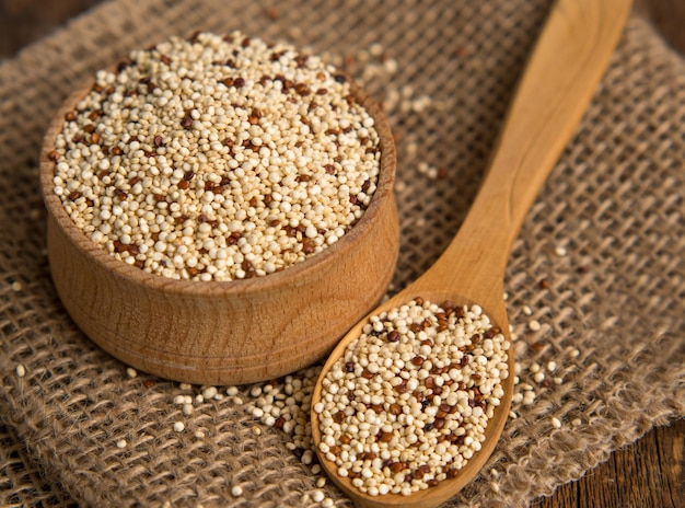 mixed raw quinoa in bowls on a wooden background Healthy and gluten free food