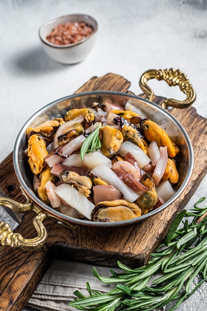 Mixed Seafood variation of fresh mussels clams squid octopus shrimps and prawn in a skillet White background Top view