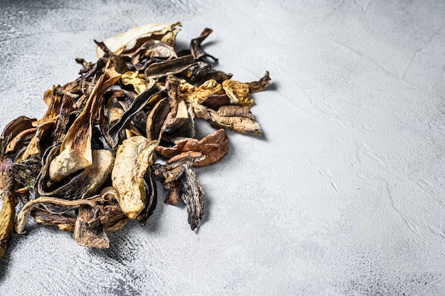 Mixed wild dried mushrooms. White background. Top view. Copy space.