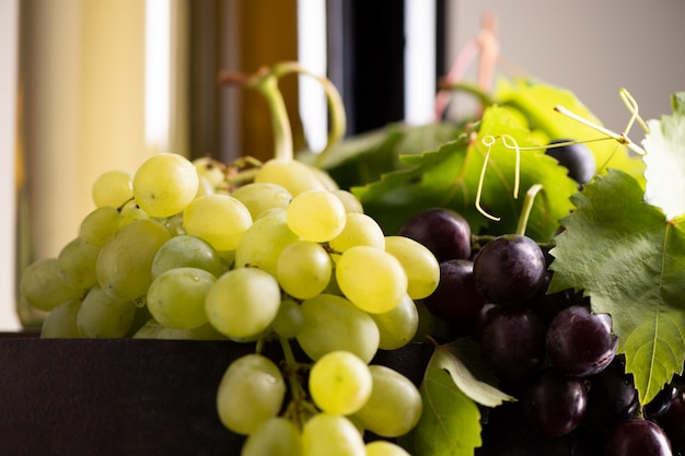 Mixes grape with bottle of wine on background