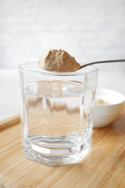 Mixing brewers yeast flakes in a glass of water