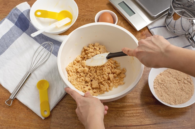 Mixing cookie dough in bowl with hands